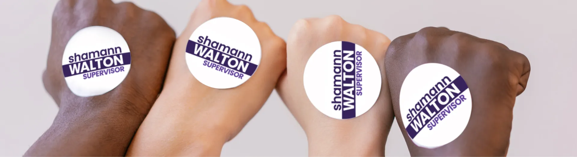 Four multi-racial fists, with political sticker on back of each hand.