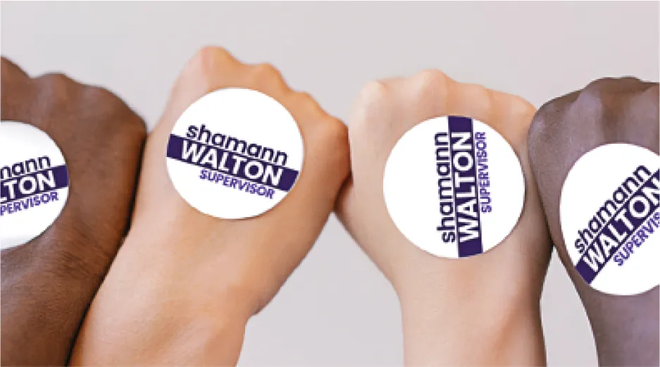 Four multi-racial fists, with political sticker on back of each hand.