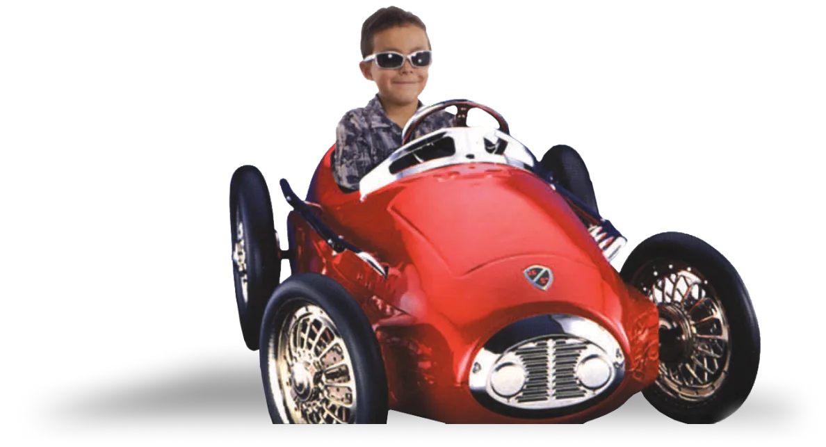 Boy sitting in red toy sports car